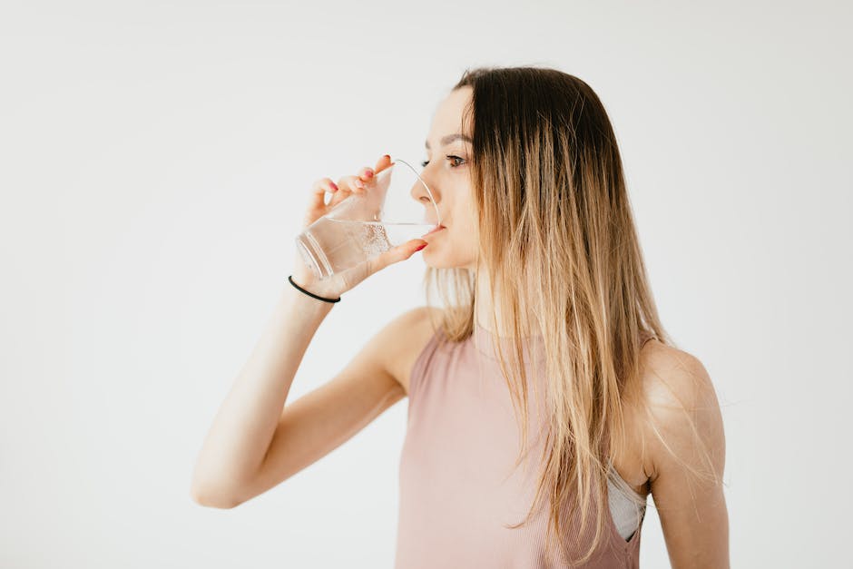 Image depicting hydration and muscle soreness, showing a person drinking water after a workout