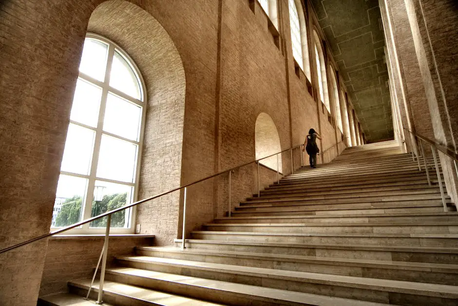 A person walking up the stairs with a hand grabbing the knee in pain.